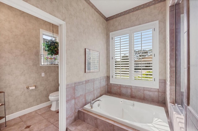 bathroom with tiled tub, tile patterned floors, and toilet