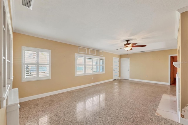 empty room featuring ceiling fan, ornamental molding, and a healthy amount of sunlight