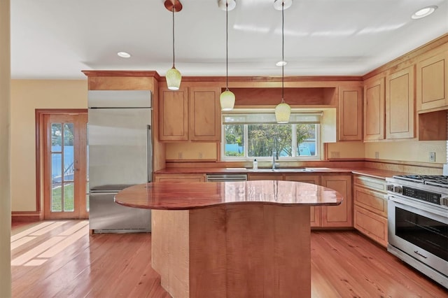 kitchen with decorative light fixtures, light brown cabinetry, appliances with stainless steel finishes, and light hardwood / wood-style flooring