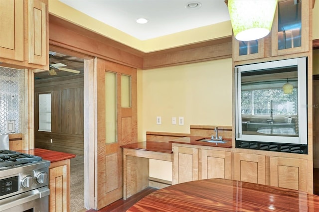 kitchen with light brown cabinetry, sink, and stainless steel gas range