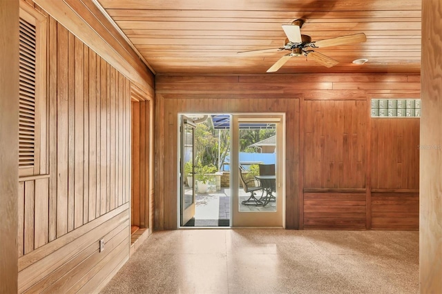 entryway featuring ceiling fan, wood walls, and wood ceiling