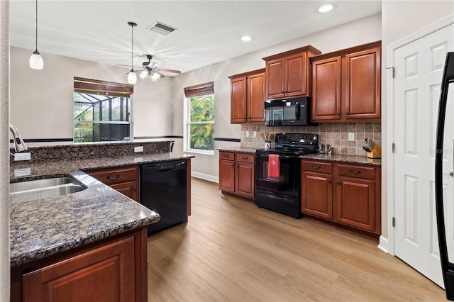 kitchen featuring black appliances, decorative light fixtures, sink, light wood-type flooring, and ceiling fan