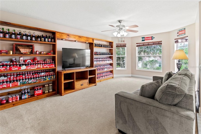 carpeted living room with a textured ceiling and ceiling fan