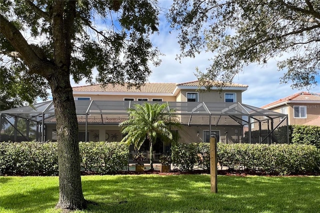 rear view of house with a lanai and a lawn