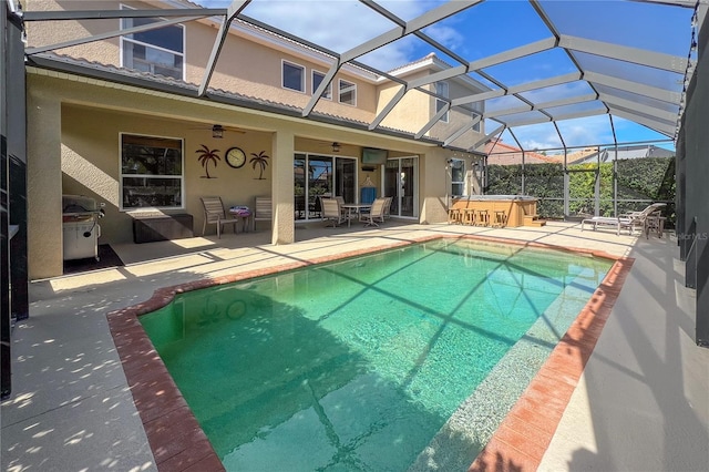 view of swimming pool with a patio area, a hot tub, glass enclosure, and ceiling fan