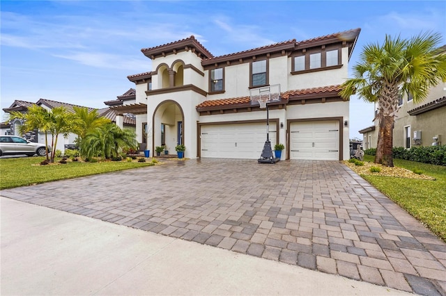 mediterranean / spanish home featuring a front yard and a garage