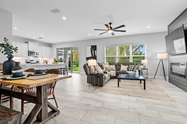 living room with ceiling fan and sink