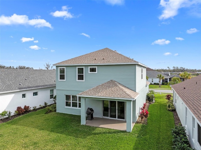 back of property with a yard and a patio