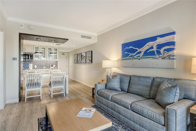 living room with crown molding and hardwood / wood-style floors