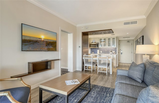 living room with crown molding and hardwood / wood-style flooring