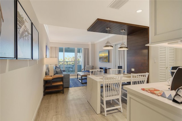 dining room featuring crown molding and light hardwood / wood-style flooring