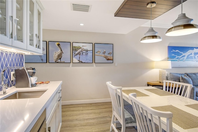 dining space featuring light wood-type flooring and sink