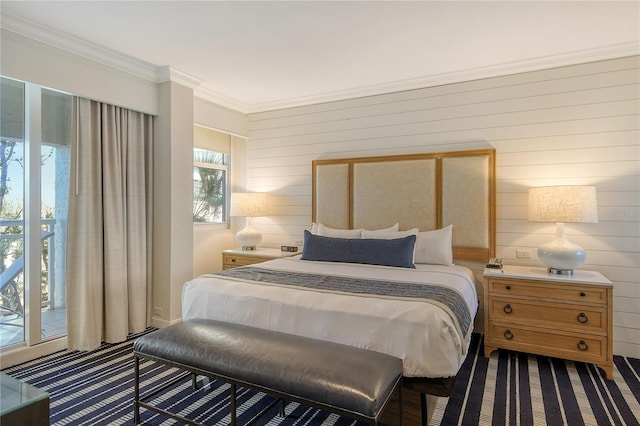 bedroom with access to exterior, crown molding, and wooden walls