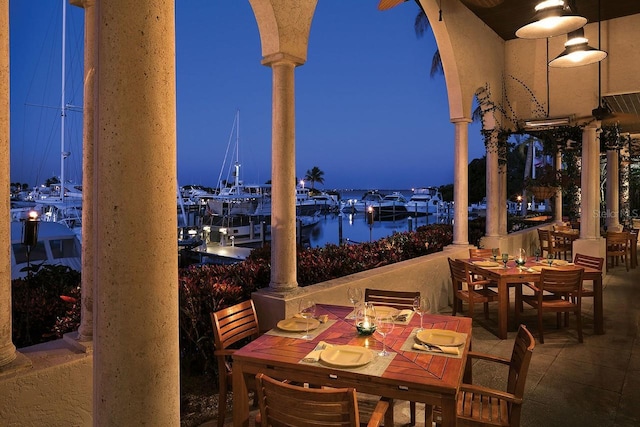 patio terrace at dusk featuring a water view