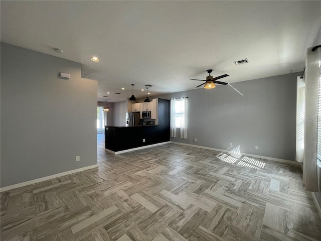 unfurnished living room with ceiling fan and light parquet flooring