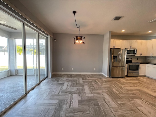 kitchen featuring decorative light fixtures, stainless steel appliances, light parquet flooring, decorative backsplash, and white cabinetry