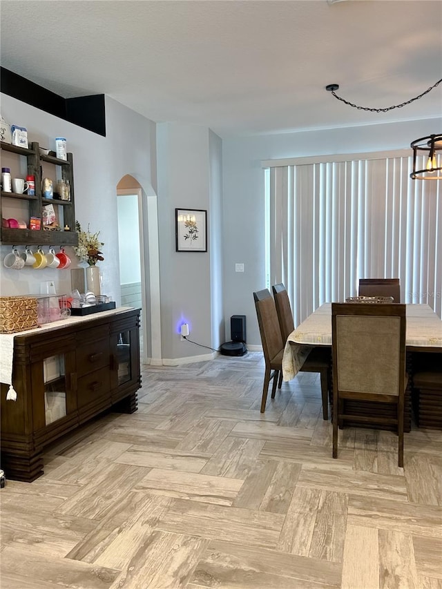 dining space with light parquet flooring and an inviting chandelier