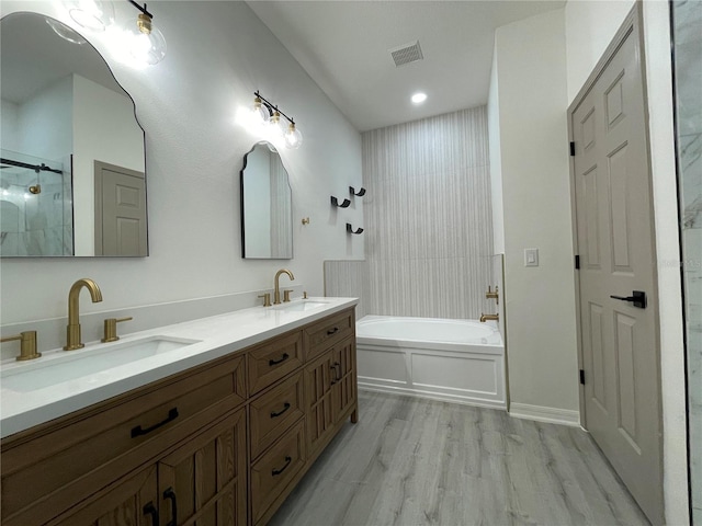 bathroom featuring separate shower and tub, wood-type flooring, and vanity