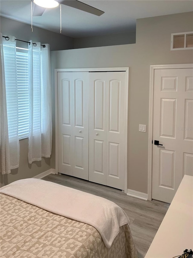 bedroom featuring ceiling fan, light hardwood / wood-style flooring, and a closet