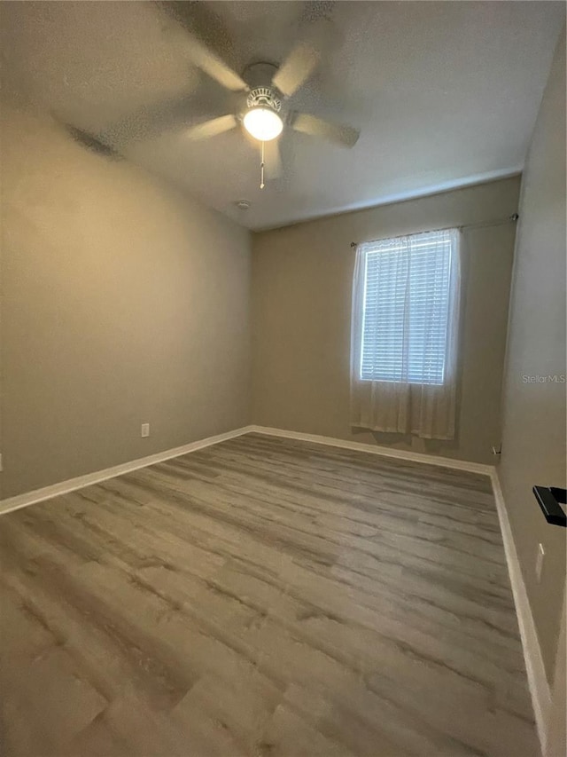 empty room featuring wood-type flooring and ceiling fan