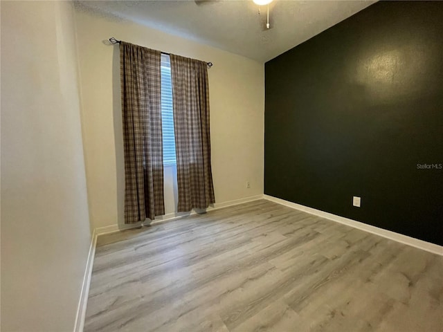 empty room featuring light wood-type flooring and ceiling fan