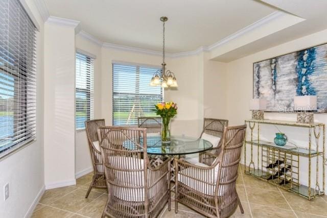 tiled dining room featuring an inviting chandelier and crown molding