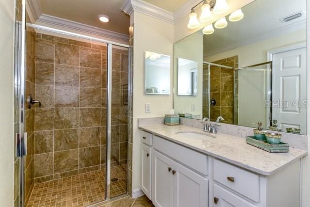 bathroom featuring ornamental molding, walk in shower, tile patterned flooring, and vanity