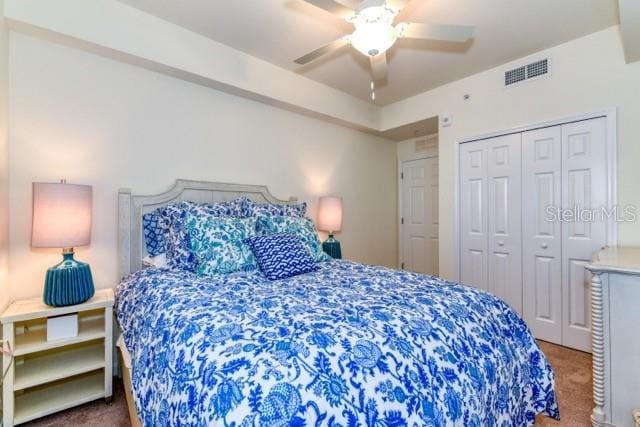 carpeted bedroom with ceiling fan and a closet