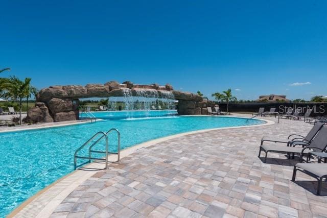 view of swimming pool with a patio area and pool water feature