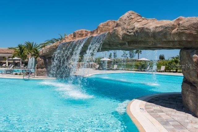 view of swimming pool with pool water feature