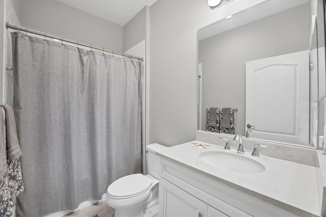 bathroom featuring toilet, a textured ceiling, and vanity