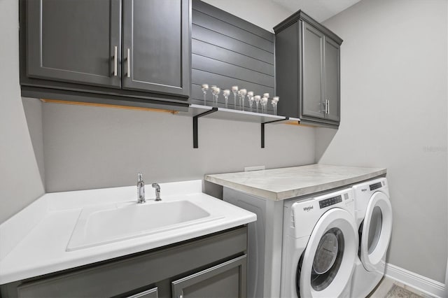 laundry area with sink, cabinets, and independent washer and dryer