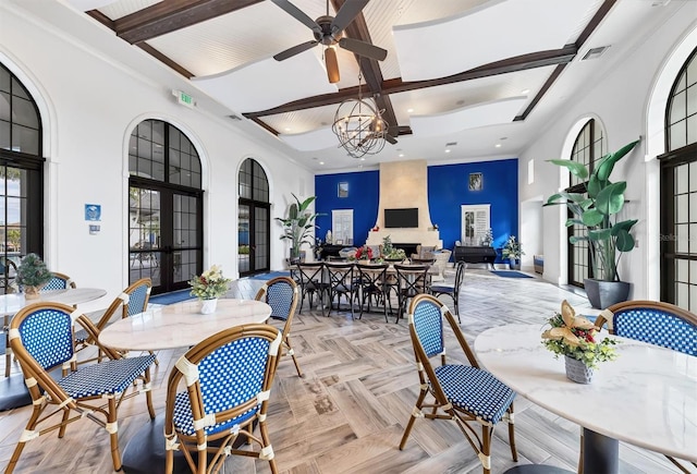 dining area featuring light parquet floors, beamed ceiling, french doors, ceiling fan with notable chandelier, and coffered ceiling