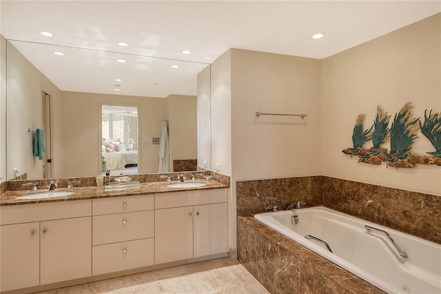 bathroom with tiled tub and vanity