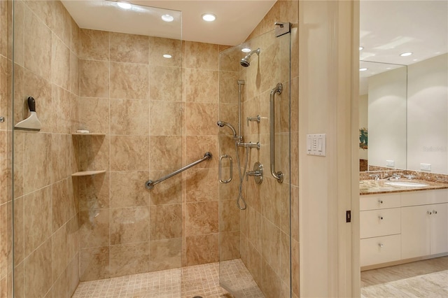 bathroom featuring walk in shower and vanity