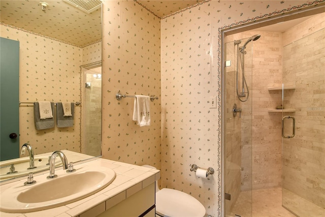 bathroom featuring a shower with shower door, toilet, and vanity