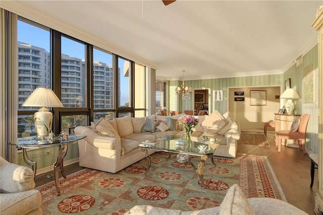 living room with an inviting chandelier, expansive windows, crown molding, and light wood-type flooring