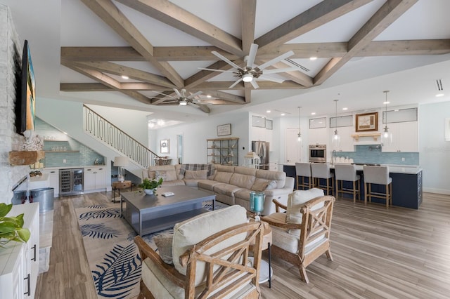 living room with ceiling fan, light wood-type flooring, beamed ceiling, and wine cooler