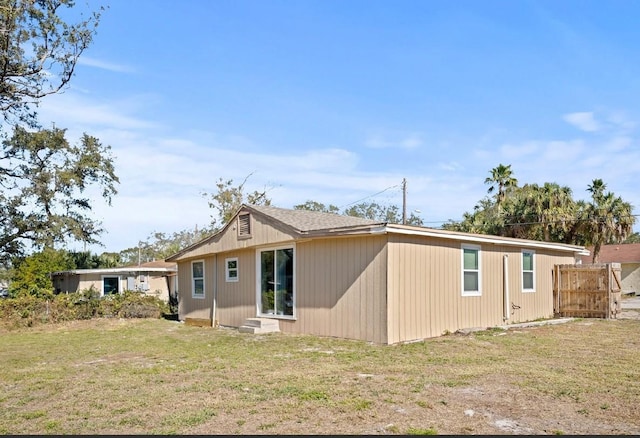 rear view of property featuring a yard