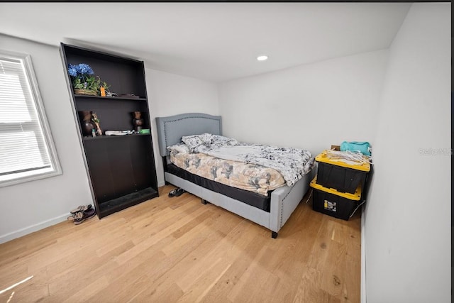 bedroom with multiple windows and light hardwood / wood-style flooring