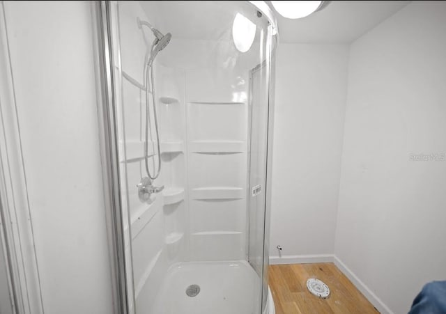 bathroom with walk in shower and hardwood / wood-style floors