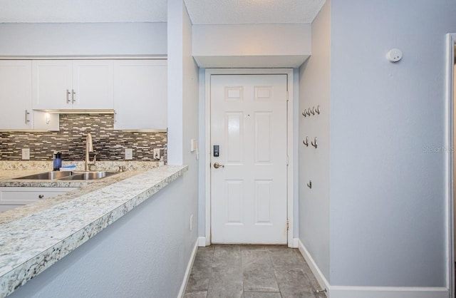 interior space with a textured ceiling and sink