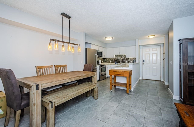 dining area featuring a textured ceiling and sink