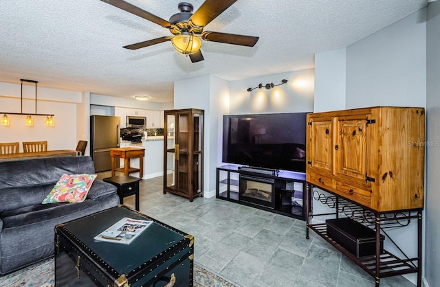 living room with a textured ceiling and ceiling fan