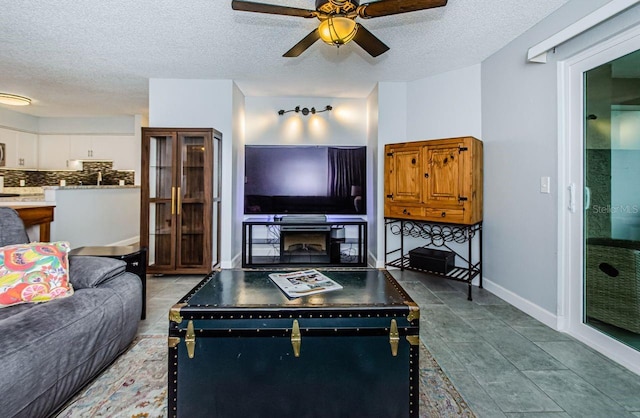 living room featuring a textured ceiling and ceiling fan