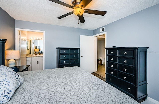 bedroom featuring ensuite bath, a textured ceiling, and ceiling fan