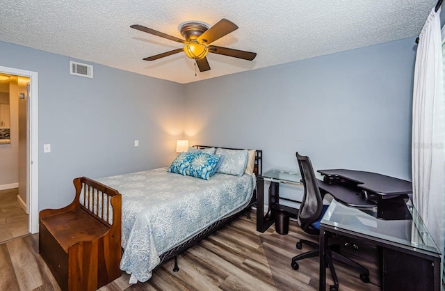 bedroom featuring ceiling fan, a textured ceiling, and wood-type flooring