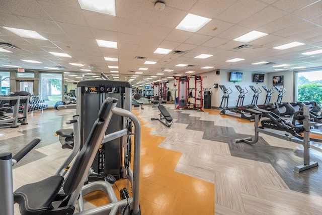 exercise room featuring a drop ceiling and a healthy amount of sunlight