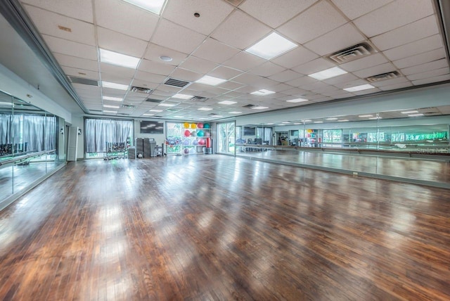 interior space with a paneled ceiling and hardwood / wood-style floors