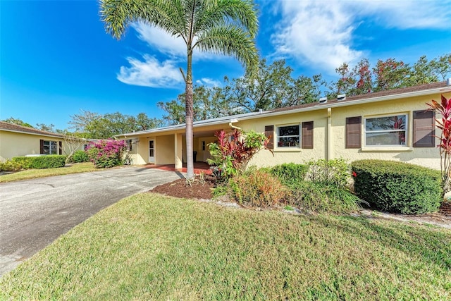 single story home featuring a carport and a front yard